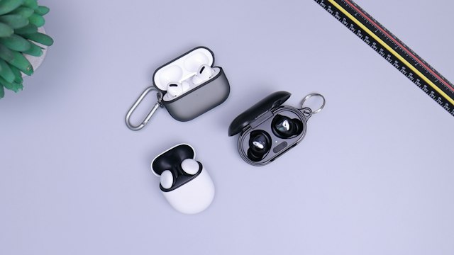 Wireless earbuds and their compact charging case on a tabletop