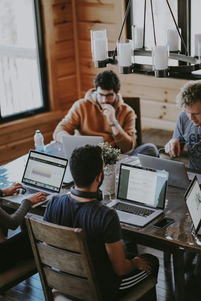 People working together at a shared table with computers