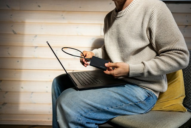 Person connecting a portable storage drive to a laptop